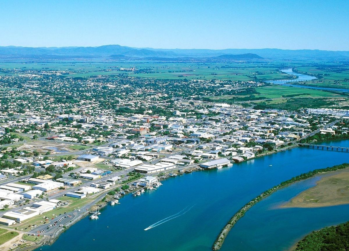 Aerial view of a coastal town with a river and mountains.