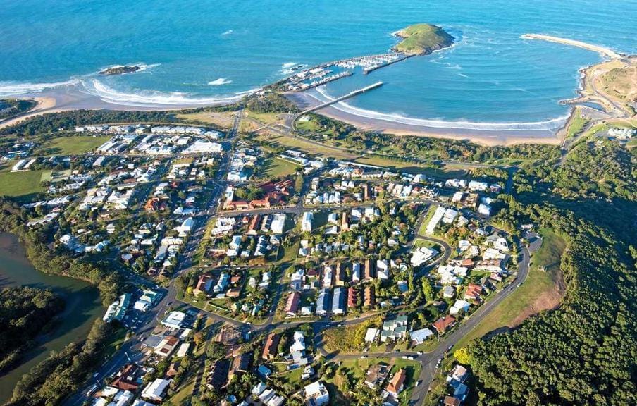 Coastal town aerial view with harbor and island.