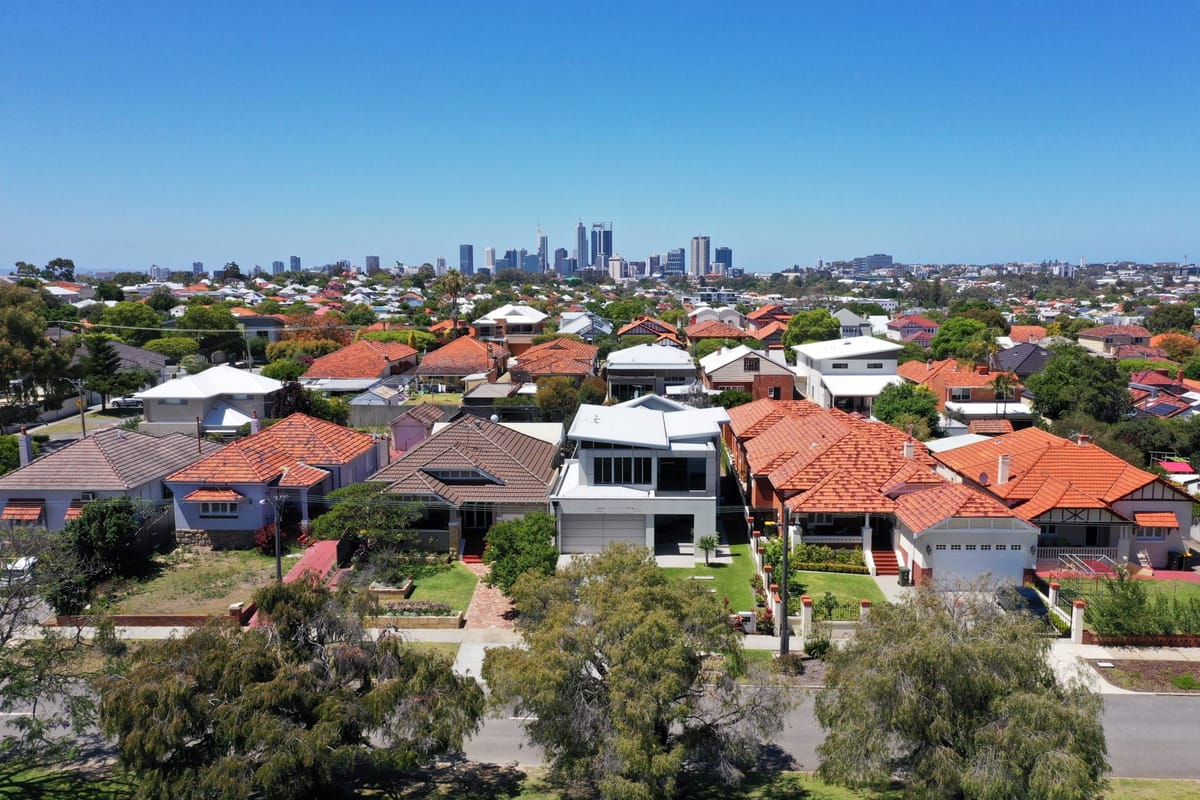 Suburban neighborhood with city skyline in the distance.