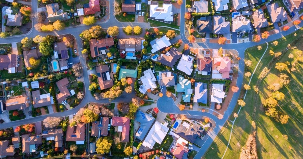 Aerial view of suburban homes with autumn foliage.