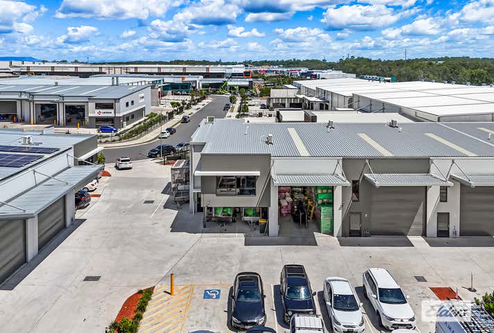 Aerial view of industrial park with buildings and parked cars.