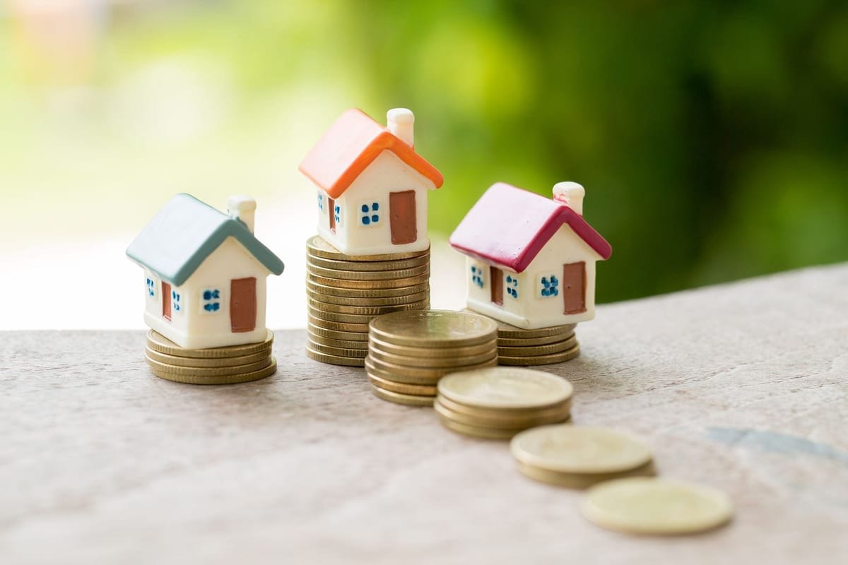 Toy houses on stacks of coins