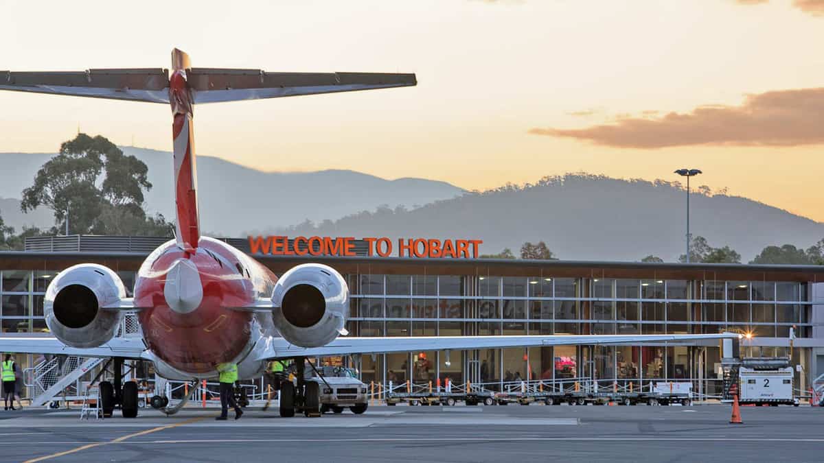 Airplane at Hobart Airport with "Welcome to Hobart" sign