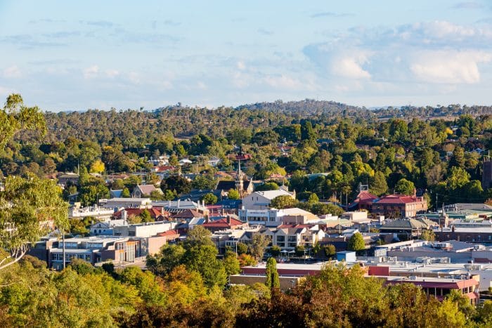 Distant aerial view of a town nestled among green hills.