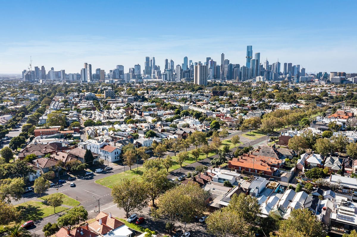 Aerial view of a city skyline over a suburban neighborhood.