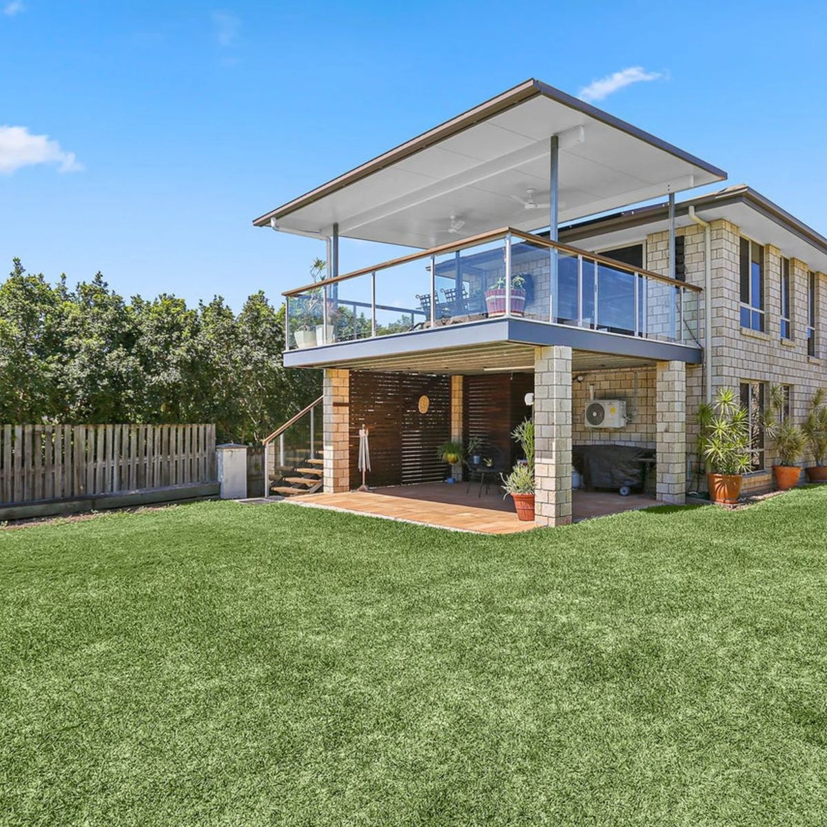 Two-story brick house with balcony and backyard.