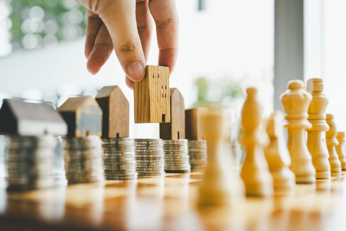 Wooden house pieces advancing across coin stacks like chess pieces