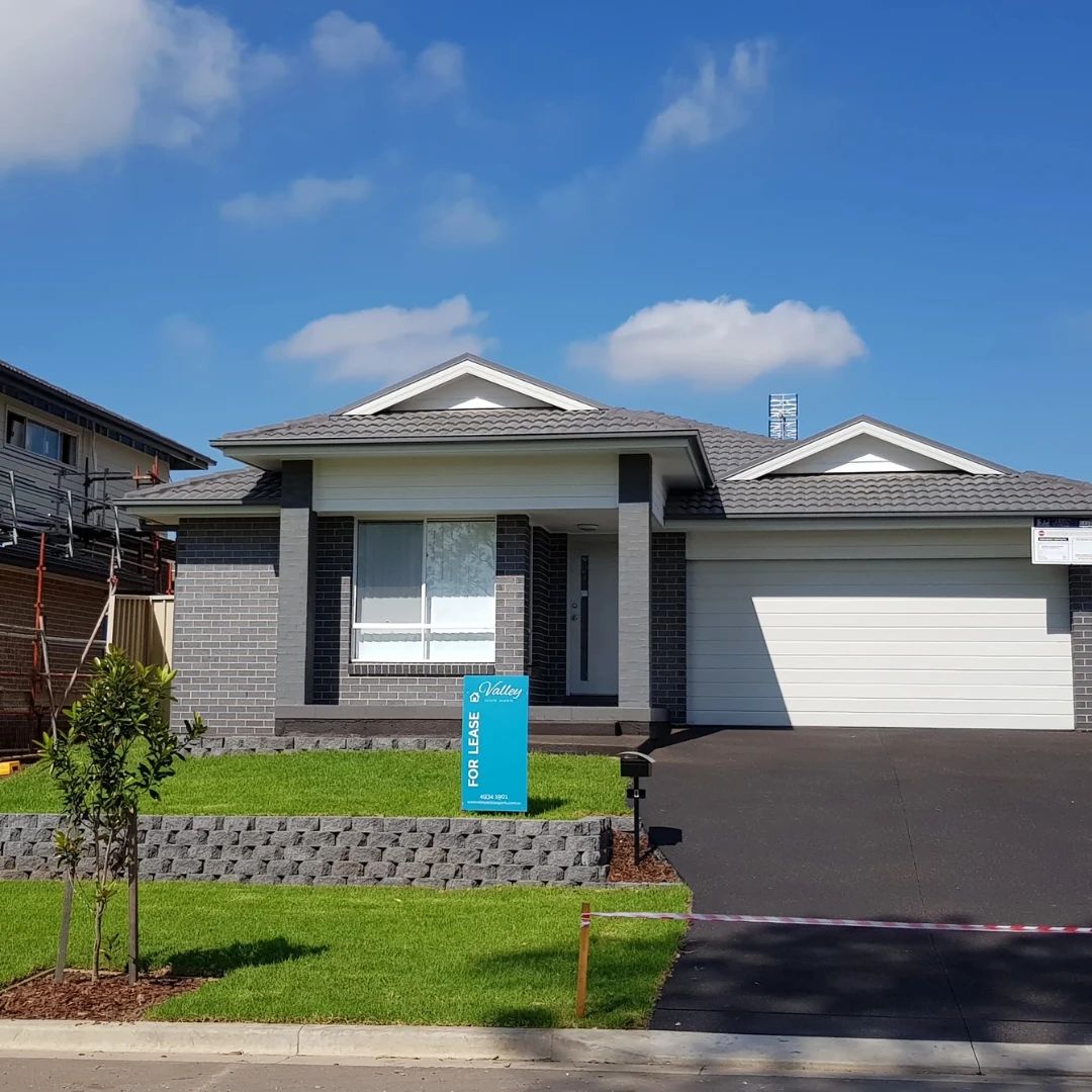 New grey brick investment home with a double garage and leasing sign in Thornton, New South Wales