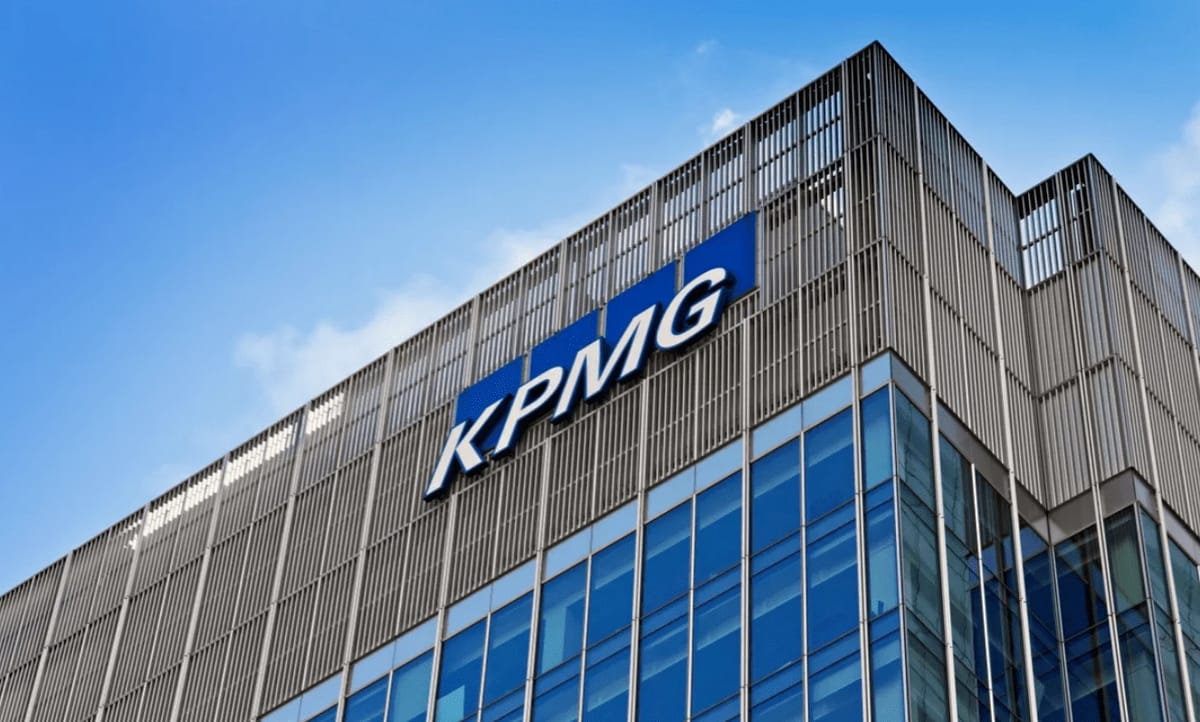 KPMG building exterior with blue logo on a clear day.
