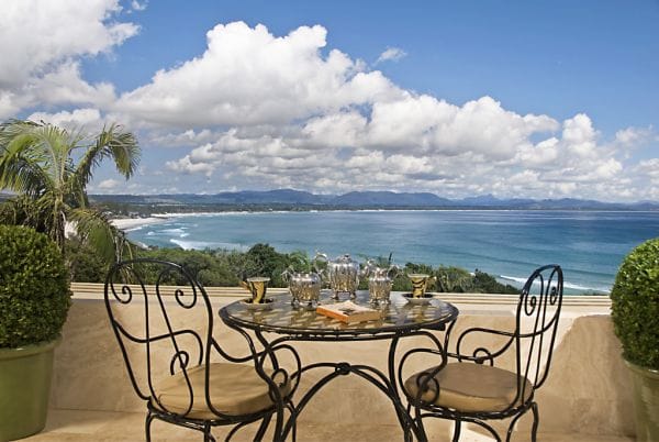 Table and chairs with tea set facing ocean view