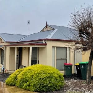 Suburban house with yellow siding and rain.
