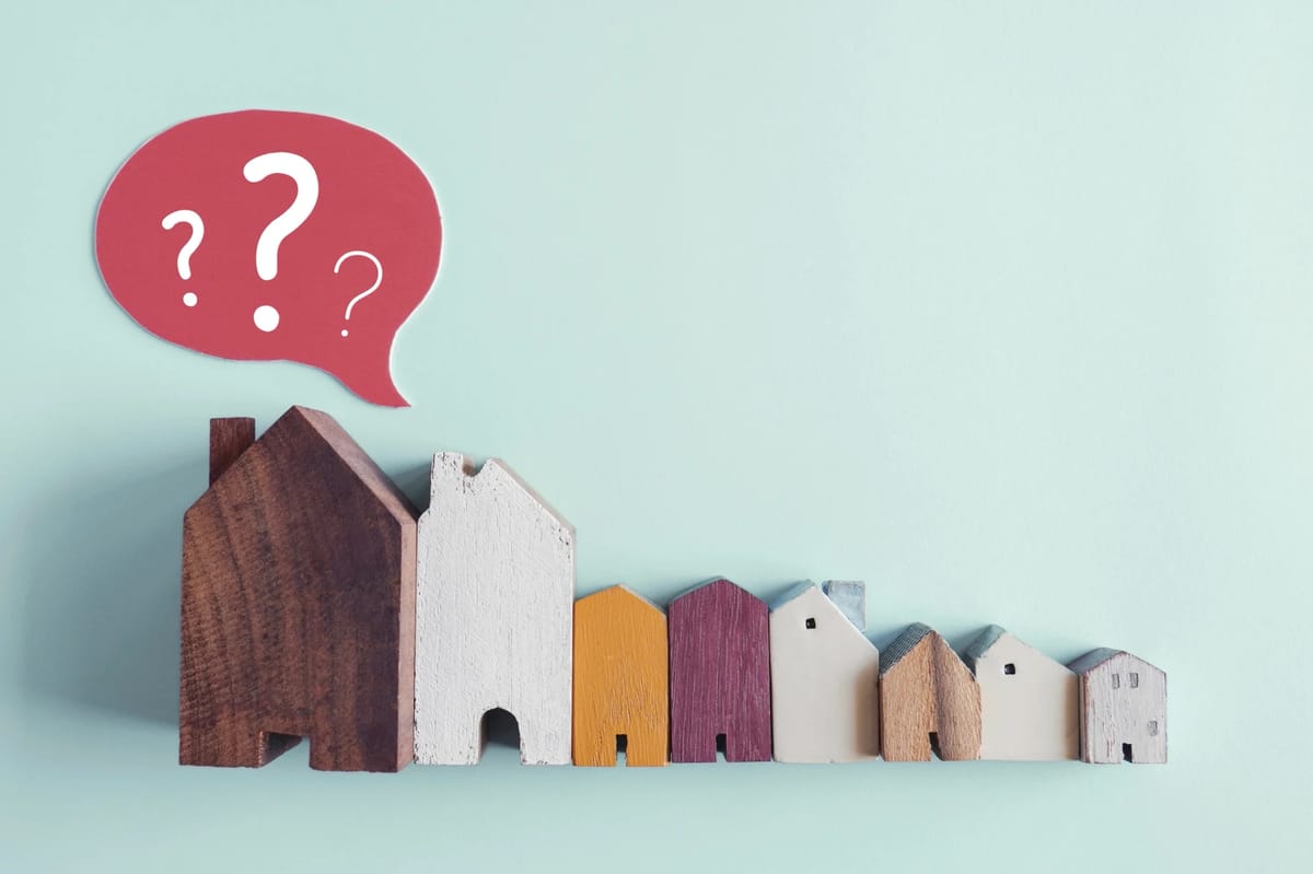Model houses arranged by size beneath a question mark