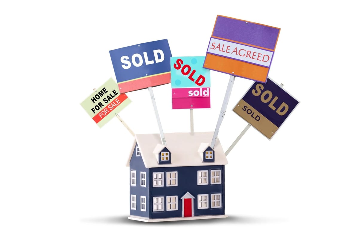 House with "Sold" and "Sale Agreed" signs