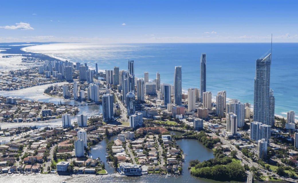 Coastal city skyline with high-rise buildings and the ocean.