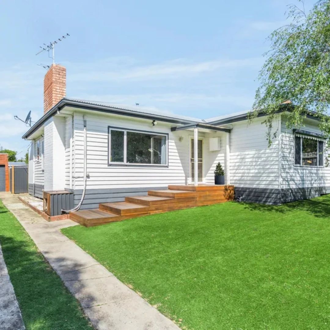 White weatherboard investment home with timber steps and green lawn in Brisbane, Queensland