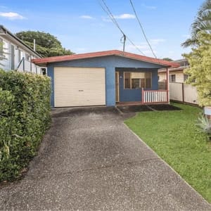 Blue house with red roof and single garage