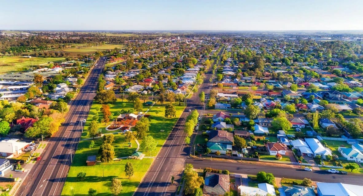 Suburban neighborhood with two roads and many houses.