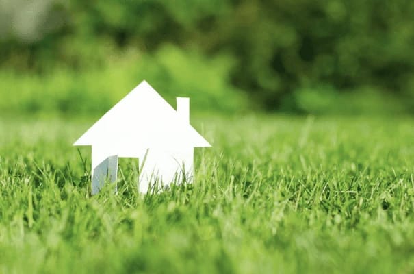 Paper house in green grass