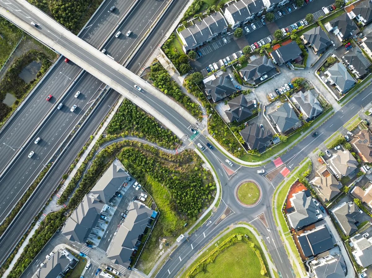 Aerial view of townhouses beside a motorway interchange