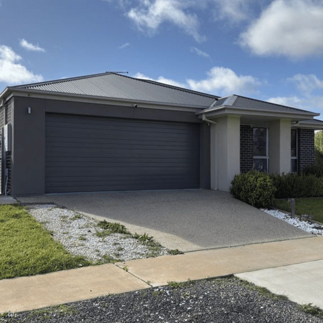 Modern house with grey garage door and driveway.