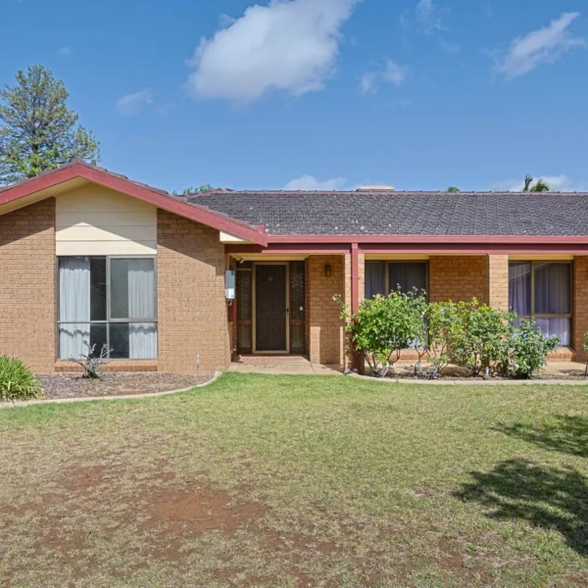 Brown brick investment home with red trim and a front lawn in Mildura, Victoria