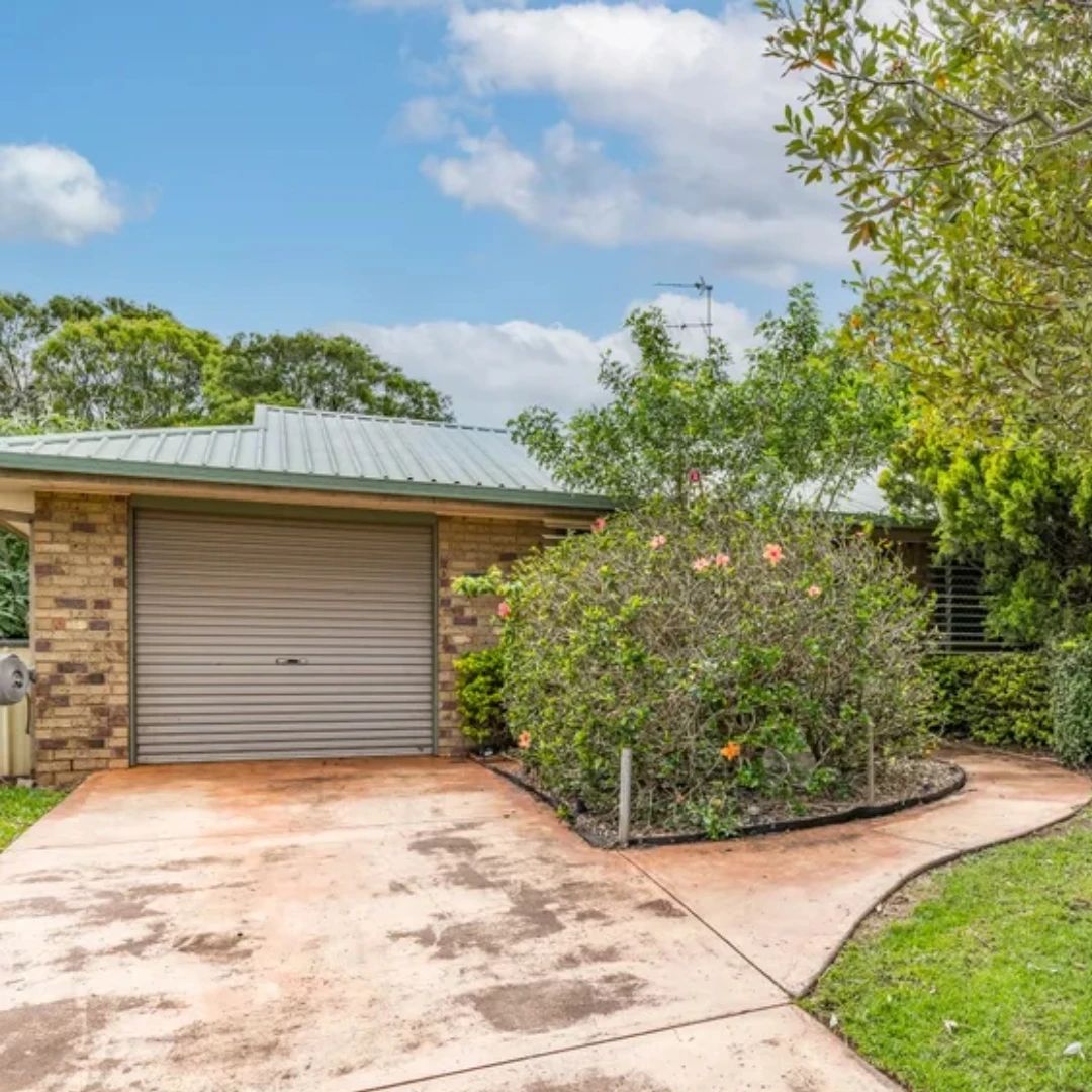 Brick investment home with a green metal roof and garden in Toowoomba, Queensland