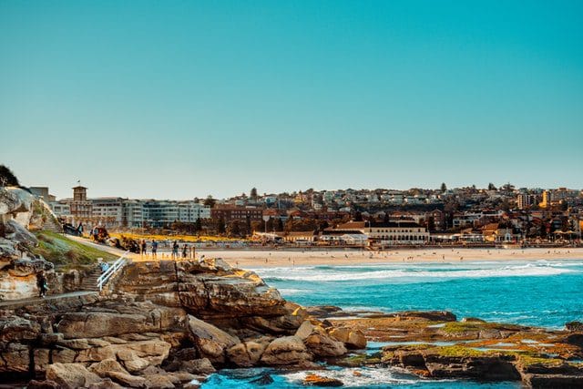 Rocky coast meets beach town with blue ocean