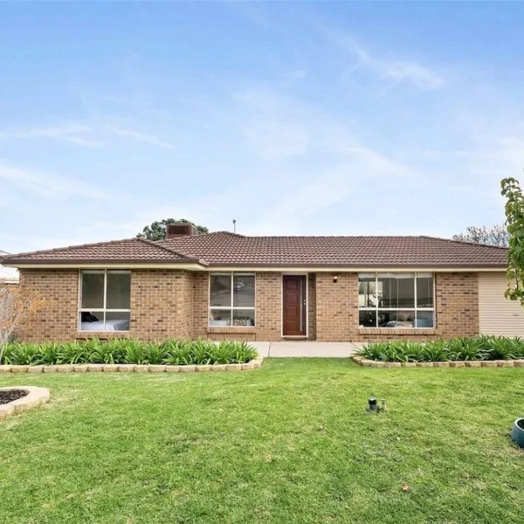 Brick house with large windows and green lawn.