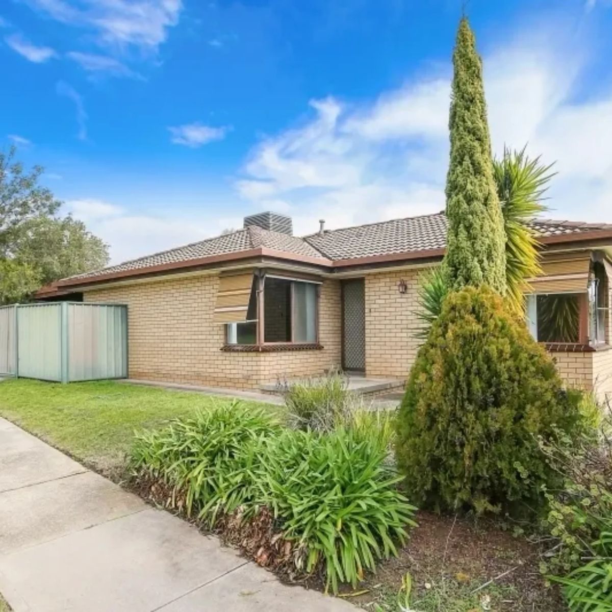 Tan brick investment home with a tiled roof and established garden in Wodonga, Victoria