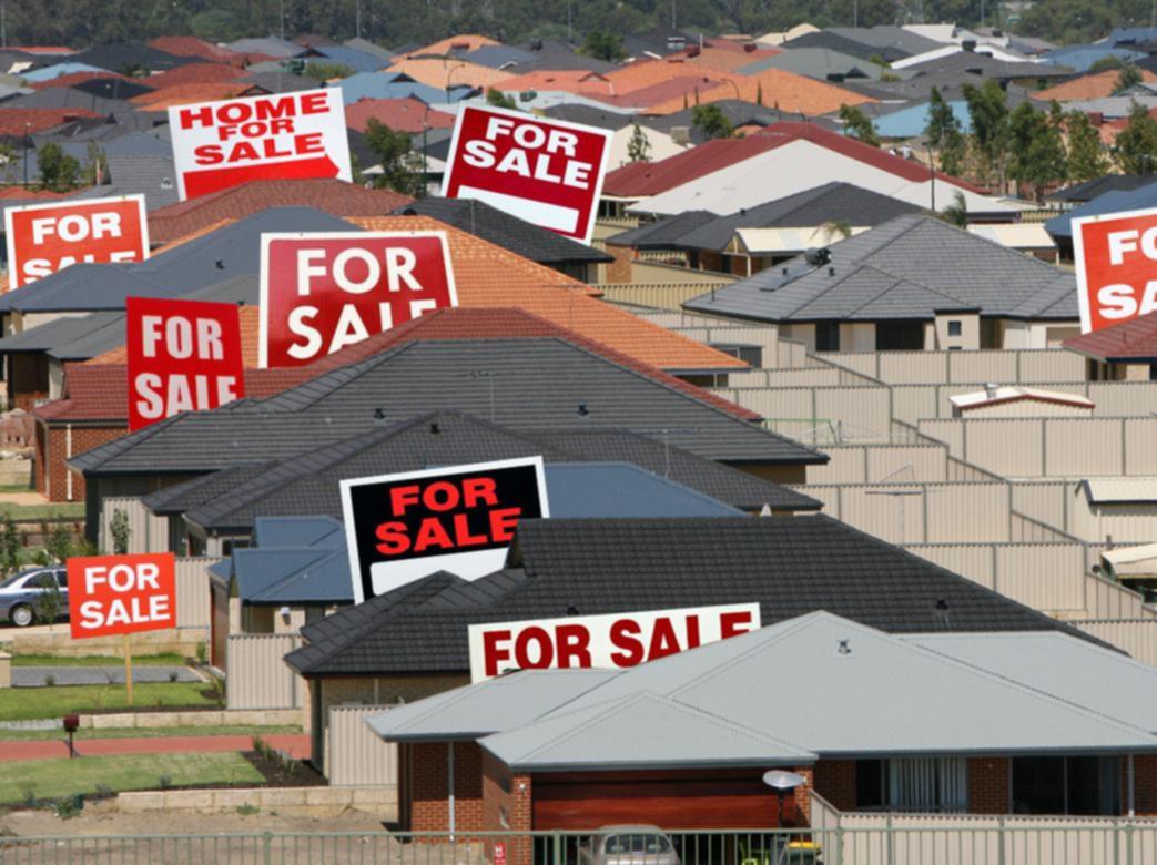 Many houses with "For Sale" signs.