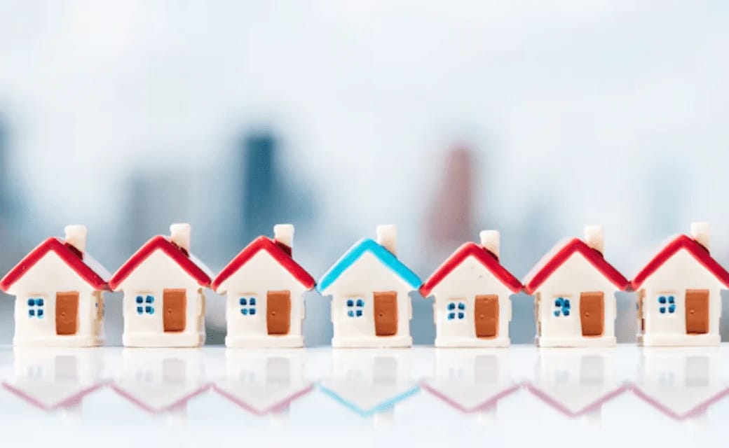 Row of miniature houses with red and blue roofs