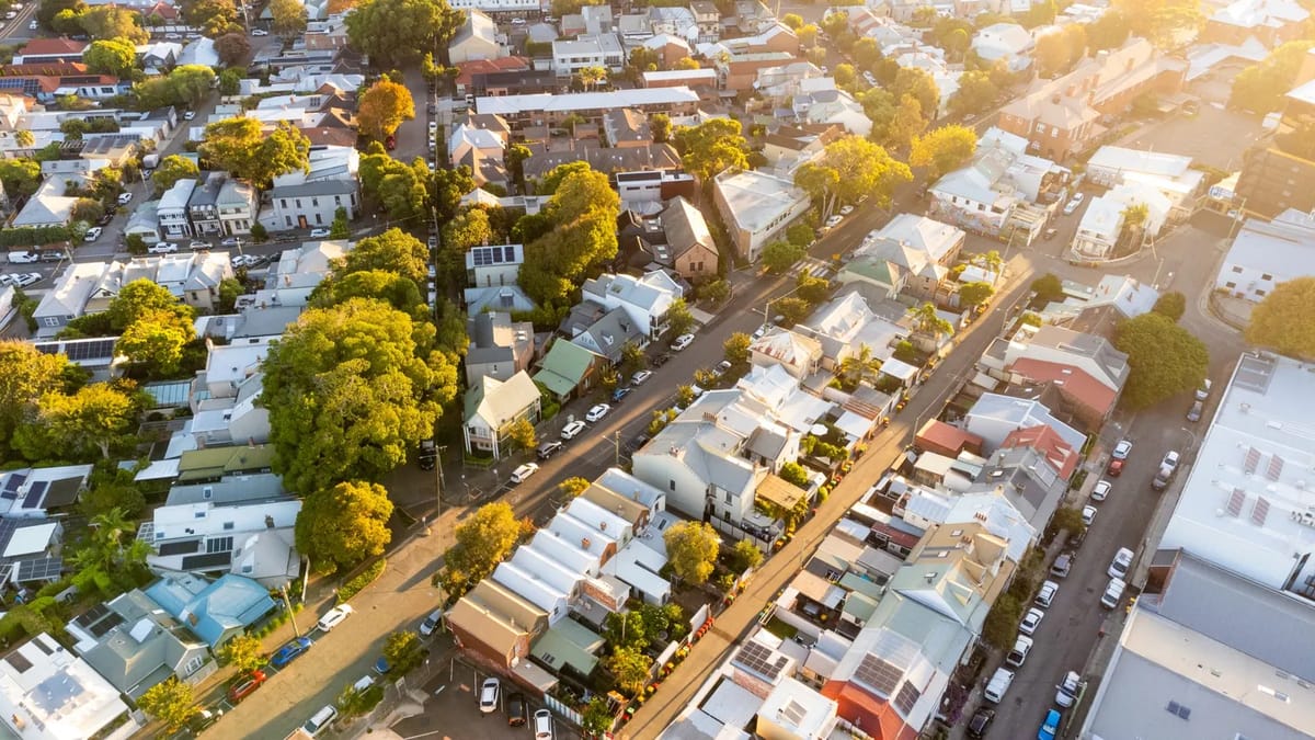 Aerial view of a dense neighborhood with houses and trees.