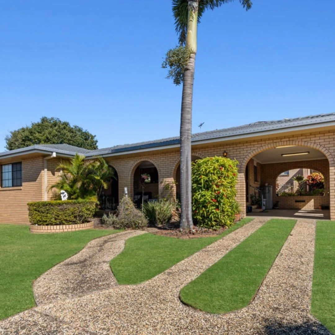Brick investment home with an arched carport and palm tree in Brisbane, Queensland