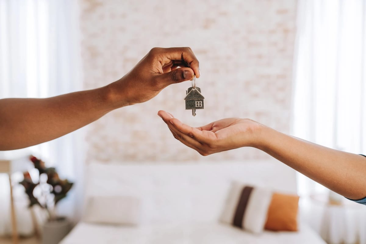 Handing over a house-shaped key.