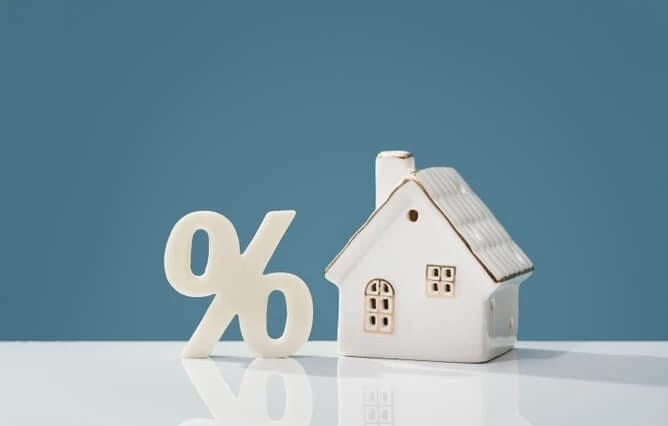 Percentage sign and house figurine