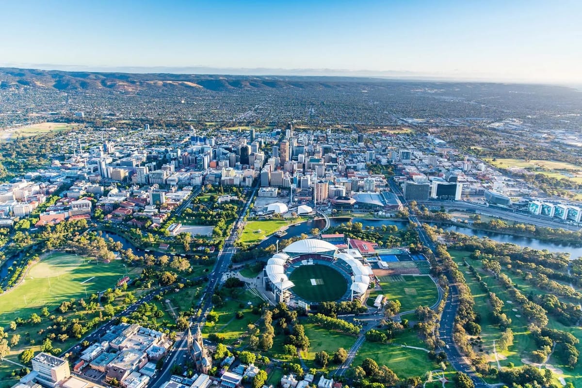 Aerial view of a city with a stadium and green spaces