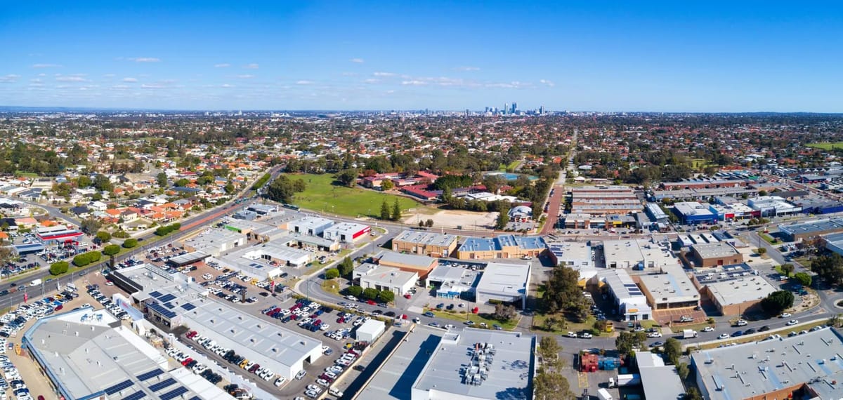 Aerial view of a suburban area with residential homes and commercial buildings.
