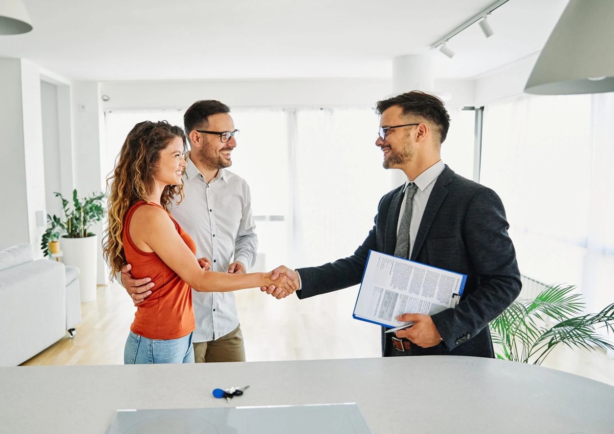 Buyer shaking hands with a property agent inside a home