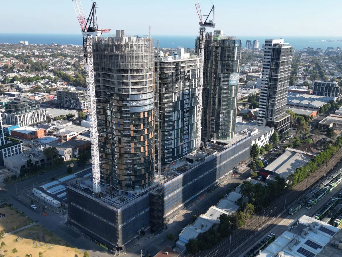 Apartment buildings under construction with cranes.