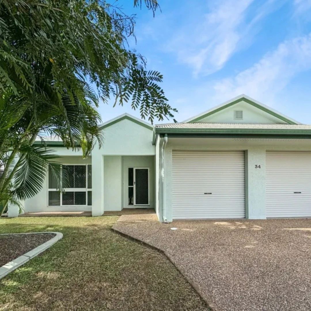 Pale green house with garage and leafy trees.