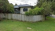 Weatherboard investment property behind a timber fence with a garden