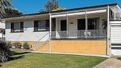 Elevated brick investment property with a wraparound veranda
