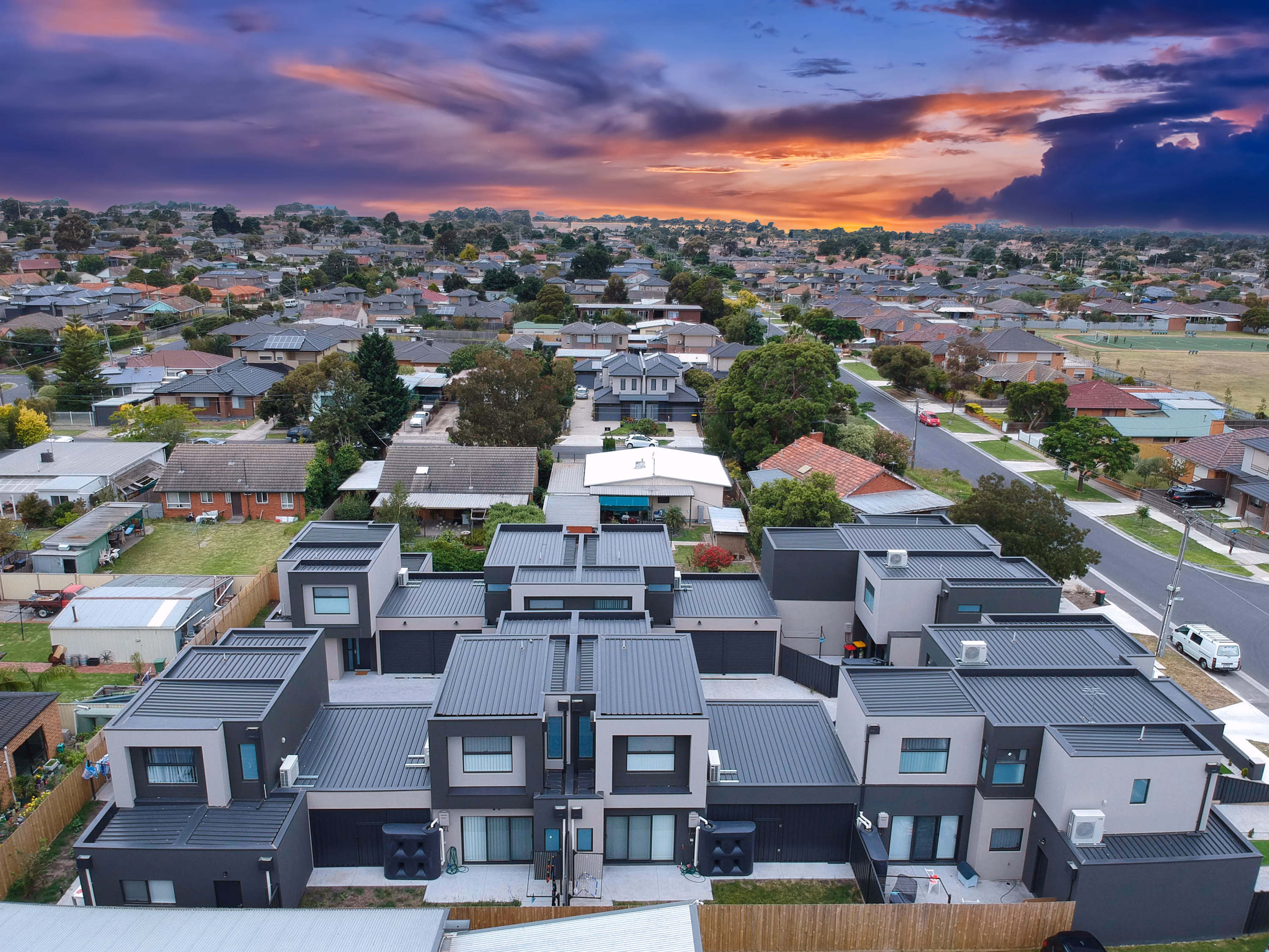 Aerial view of townhouses and detached homes in an Australian suburb at sunset