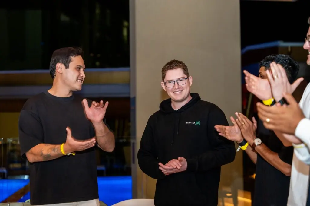 Men clapping for another man in a hoodie.