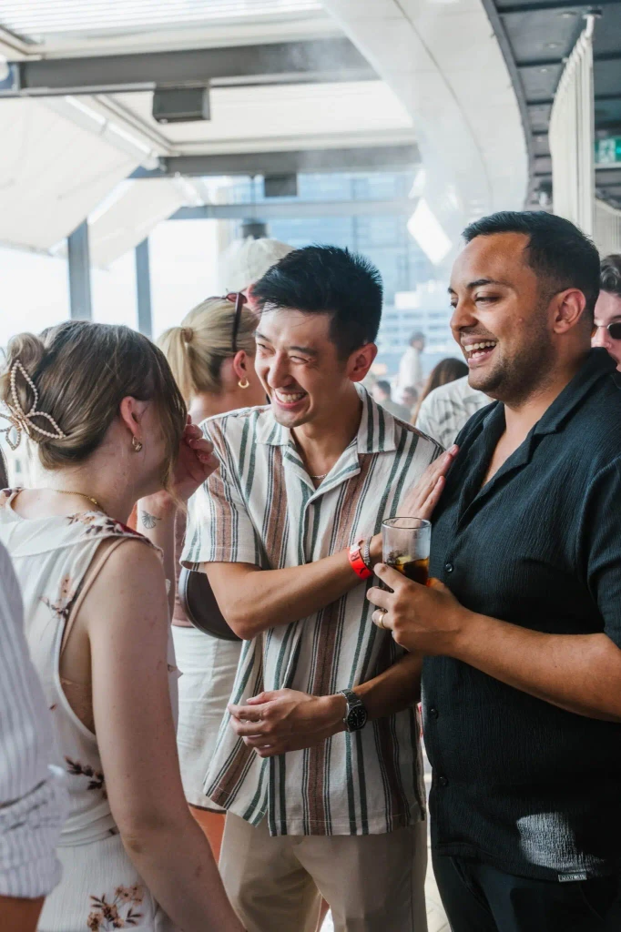 Three people laughing and talking at an event.
