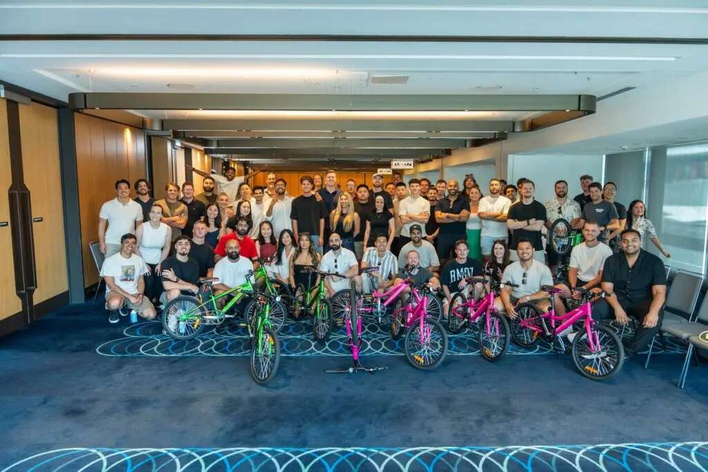 Group of people with bright pink and green bicycles