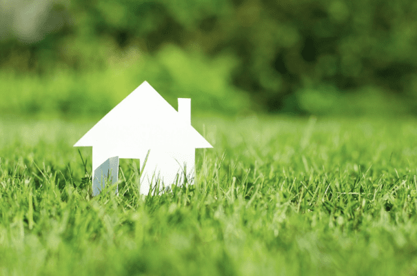 a paper cut out of a house in the grass